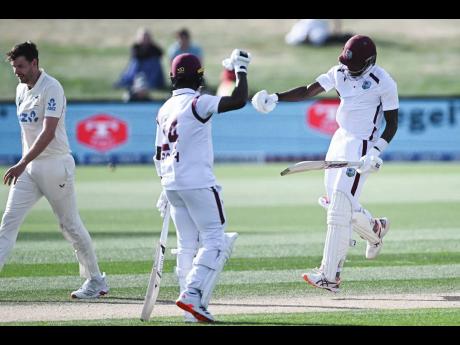 West Indies’ Justin Greaves (right) celebrates with teammate Kemar Roach (centre) after scoring 200 runs against New Zealand on day five of their cricket Test match in Christchurch, New Zealand, on Saturday.