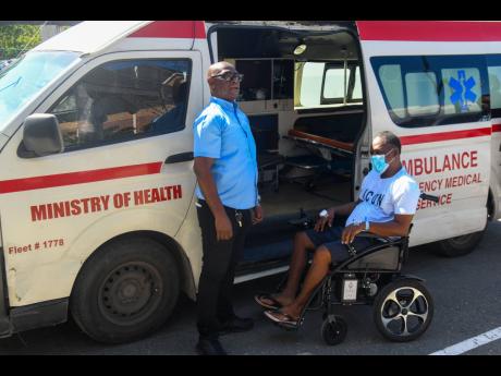 Kevin Henry (right) is escorted by ambulance to the Chinese medical ship, Silk Road Ark yesterday. The ship is docked in Port Royal.