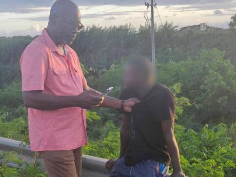Credit: -Contributed photo Councillor Scean Barnswell (left) detains the man who allegedly abducted a six-year-old girl in Clarendon on December 9, 2025.