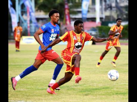 Credit: Ashley Anguin Cornwall College’s Marcane Gooden (front) dribbles the ball away from Kemps Hill High’s Orlando Campbell during their Group 1 football match in the second round of the ISSA daCosta Cup at Montego Bay Sports Complex on Saturday, October 11. Cornwall won 2-0.