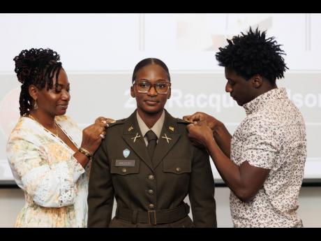 Racquel Wilson (centre) pinned by mother, Marian Brown Stewart (left) and brother, Romaine Wilson.