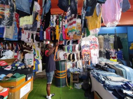 Clothes vendor Courtney ‘1Boom’ Hanson shows some of his apparel up for sale, but not many buyers are coming this Christmas.