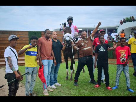 INTRESTINTIMESAHEAD, with Anthony Allen aboard, parades with connections in the winners’ enclosure after landing the third running of the WILL IN CHARGE Trophy at Caymanas Park on Sunday.