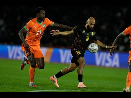 Cameroon’s Bryan Mbueno (right) is challenged by Ivory Coast’s Evan Ndicka during the Africa Cup of Nations group E soccer match in Marrakech, Morocco on Sunday.