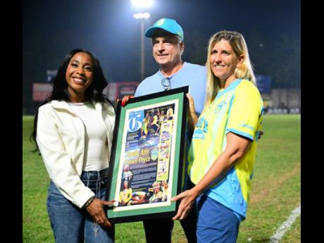 Shelly-Ann Fraser-Pryce (left) recieves a citation from the Waterhouse Football Club, presnted by Bruce Bicknell (chairman, Waterhouse FC) and Nicola Bicknell (director, Waterhouse FC) in honour of her achievements in track and field. The presentation took place at half-time during the Molynes FC vs Waterhouse FC Jamaica Premier League fixture.
