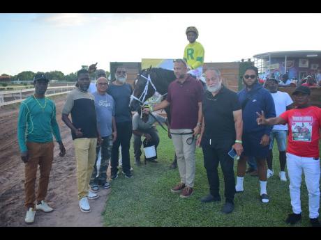 LEGACY ISLES (centre), with Raddesh Roman in the saddle, parades with connections after winning the Chris Harmond Memorial Sprint over 5 1/2 furlongs at Caymanas Park on Saturday.
