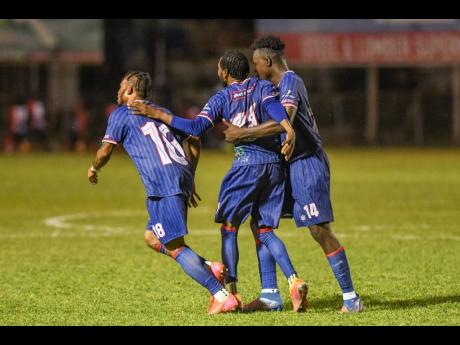 Three members of the Spanish Town Police FC team - (from left) Lamar Davis, Jordan Elliston and Shamar Harris - celebrate after they scored a goal against Waterhouse FC during their Jamaica Premier League match  at the Anthony Spaulding Sports Complex  on December 15, 2025. Spanish Town Police won 2-1.