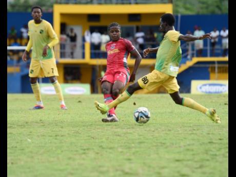 Montego Bay United’s Clarens Gilles (centre) is challenged by Treasure Beach FC’s Chandol Anderson during their Jamaica Premier League football game at St Elizabeth Technical High School on Sunday. MoBay United won 2-1.
