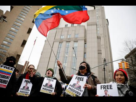 Protesters hold signs calling for Maduro's release outside Manhattan Federal Court before his arraignment. (AP Photo/Stefan Jeremiah)