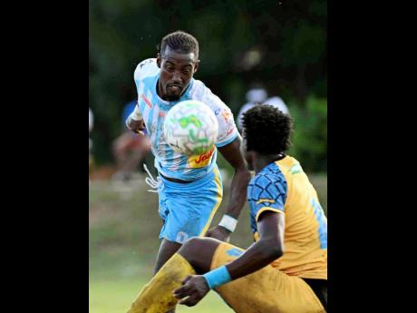 Waterhouse FC striker Javane Bryan misses an attempt to head the ball while under pressure from Racing United FC’s Chavany Willis during the Jamaica Premier League football match at Ferdi Neita Park on Sunday.