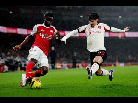 Credit: AP Liverpool’s Milos Kerkez extends himself in an effort to block Arsenal’s Buyako Saka (left) during the English Premier League soccer match at Emirates Stadium in London, England, on Thursday, January 8, 2025.