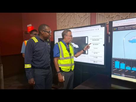 JPS president and CEO Hugh Grant and Energy Minister Daryl Vaz