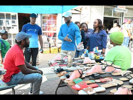 Mayor of Montego Bay and Chairman of the St James Municipal Corporation, Councillor Richard Vernon (centre), interacts with vendors in downtown Montego Bay last Friday.