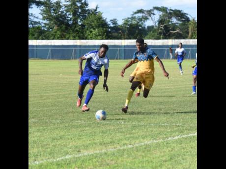 Mount Pleasant Academy’s Jahshaun Anglin (left) and Racing United’s Tajay Grant  battle for the ball during their Jamaica Premier League match at Drax Hall Sports Complex yesterday.
