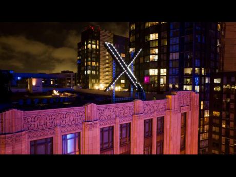 Workers install lighting on an ‘X’ sign atop the company headquarters, formerly known as Twitter, in downtown San Francisco in November 2023. 