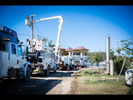 A row of JPS bucket trucks in Westmoreland signals active work on the power infrastructure leading to the National Water Commission’s Roaring River plant.