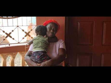 Credit: Simone Morgan-Lindo Grief and comfort intertwine as Janet Henry hugs her 18-month-old grandson.