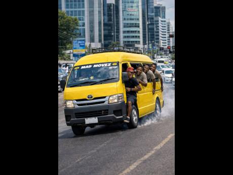 AI-generated image of a minibus speeding recklessly through a busy Corporate Area in Kingston, with passengers hanging out of the open doors.