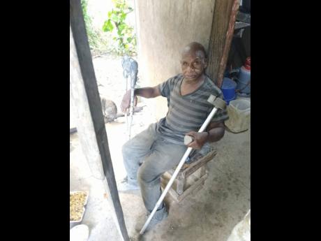 Vincent Trowers, 72, sits outside the fragile shelter he calls home in Marlborough, St Mary.