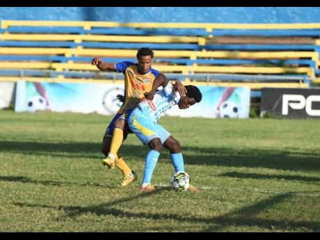 Luca Kung (left) of Harbour View and Duwayne Burgher of Waterhouse battle for the ball during yesterday’s Jamaica Premier League match at the Harbour View Mini Stadium. The game ended in a 1-1 draw.