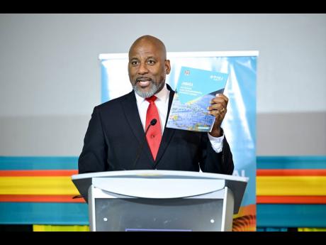 Director General of the Planning Institute of Jamaica (PIOJ), Dr. Wayne Henry, displays a copy of the Jamaica National Multidimensional Poverty Index (MPI) during the official launch ceremony for the Index at the AC Marriott Hotel in St Andrew on January 16.