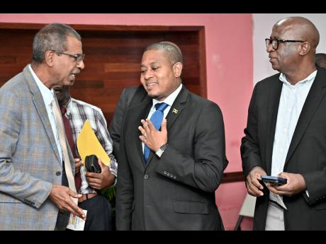Floyd Green (centre), minister of agriculture, fisheries and mining, chats with Dr Gavin Bellamy (left), CEO of National Fisheries Authority, and Orville Palmer, chief technical director in the ministry, at its media briefing on Hurricane Melissa recovery in Hope Gardens, St Andrew, on Tuesday.