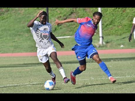 Credit: Rudolph Brown Shamar Watson (left) of Cavalier dribbles away from Nevaun Turner of Dunbeholden during their Jamaica Premier League match at the Stadium East field yesterday. Cavalier won 5-1.