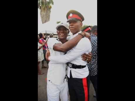 Constable Rohan Francis (left), gets a congratulatory hug from his father Carlton Francis shortly after he graduated.