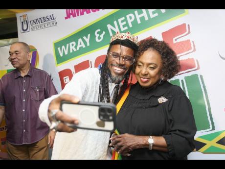LA Lewis (left) said he had to take a selfie with Culture Minister Olivia Grange at the Reggae Month launch on Wednesday.