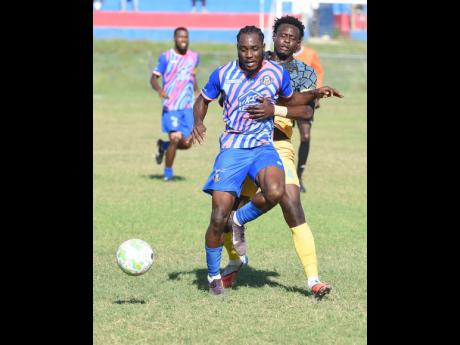 Akeem Mullings of Portmore United is challenged for the ball by Chavany Willis (right) of Racing United during their Jamaica Premier League football match at Ferdi Neita Park on Sunday.