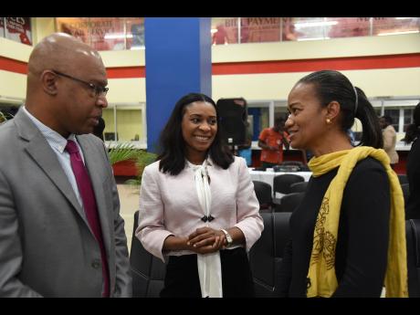 Credit: Ian Allen Lincoln Allen (left), postmaster general, Post and Telecommunications Department, chats with Dr Taneisha Ingleton (centre), managing director, HEART/NSTA Trust, and Wahkeen Murray, chief technical director, Office of the Prime Minister, during yesterday’s official launch of the department’s Staff Empowerment Programme. It was held at the department’s Central Sorting Office in Kingston.