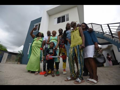 From the ashes of a seven-bedroom blaze two years ago, this family stands together today, keys in hand, in front of a brand-new home in Brooks Level, Stony Hill, St Andrew. The new dwelling promises hope and a fresh start.