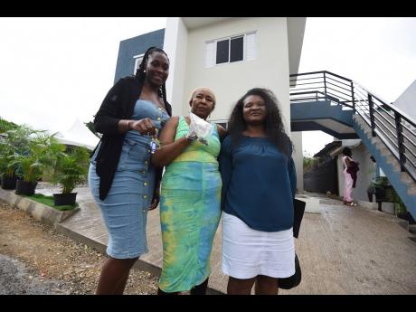 Trissan Bartley (left), Marva Harrison (centre) and Sennette Hinds stand proudly outside their brand-new apartments at Brook Level, Stony Hill, St Andrew, last Friday, finally reclaiming a home after fire destroyed their previous house.