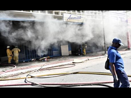 Thick smoke rises from the 65-year-old clothing store, sending neighbouring shops into emergency mode.