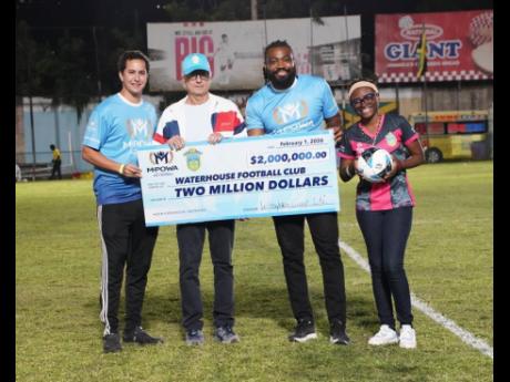 Jake Mahfood (left), commercial and  development manager of Wisynco, hands over his company’s $2 million cheque to Bruce Bicknell (second left), chairman of the Waterhouse FC, on Sunday at the Waterhouse Mini Stadium. Looking on are Chevon Lewis (second right), brand manager of MPOWER and Aundreen Leslie, social media officer of Waterhouse. 