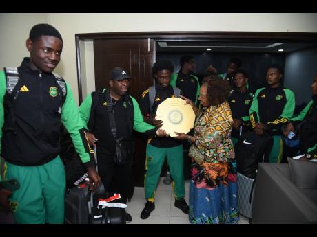 Credit: Audley Boyd Sports Minister Olivia Grange (front, right) holds the Concacaf Under-17 Championship Shield as she interacts with members of the national under-17 men’s football team upon their arrival at the Norman Manley International Airport last night. The under-17 Reggae Boyz topped the Concacaf U17 Championship Final in Costa Rica and booked their ticket to the FIFA U17 World Cup, which will be held in Qatar in November.
