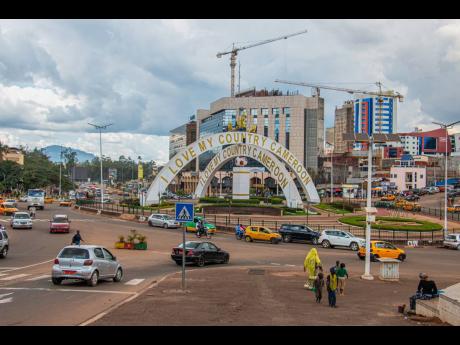 Credit: AP Cars drive through an intersection near a monument in Yaoundé, Cameroon.