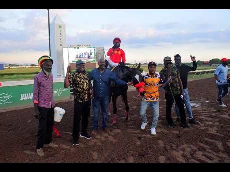 Credit: Anthony Minott WALL STREET TRADER, with Christopher Mamdeen aboard, pose with connections after winning the Ash Wednesday Trophy, an Overnight Allowance Stakes, at Caymanas Park on Wednesday.