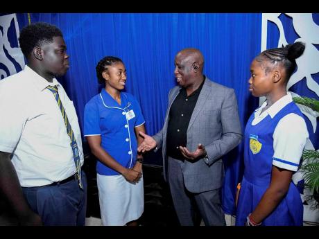 Ricky Martin (second right), CEO of Corporate Area Championships, in dialogue with Ricardo Smith, discus and shot put athlete of Penwood High School (left), Shanakay Morris, discus and shot put athlete of Penwood High School (right), and Dacia McDonald, javelin and shot put athlete of Immaculate High School, at the media launch for the Corporate Area Champs on February 10 at the National Housing Trust Sports Club. 