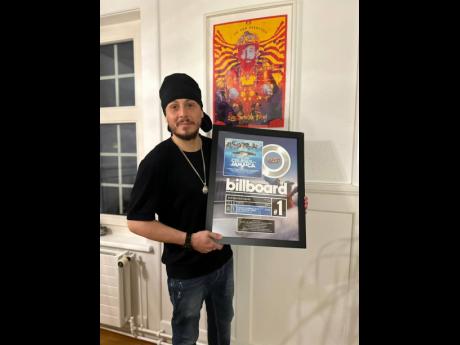 Cookie the Herbalist displays his Billboard Reggae No. 1 plaque for the compilation album ‘Tropical House Cruises to Jamaica’.
