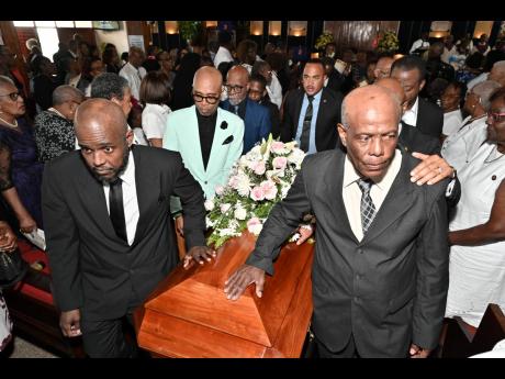 Terrence Kelly (right), husband, and Daviot Kelly (left), son of the late Joan Vivene Kelly, join pallbearers in carrying her casket during the service of thanksgiving for her life at Meadowbrook United Church on Flemington Drive in Kingston on Friday, February 20, 2026. Kelly was a former vice-principal of Holy Childhood High School.