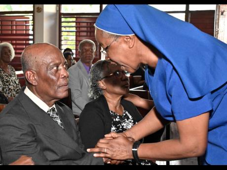 Sister Maxine McIntosh greets Terrence Kelly, husband of the late Joan Vivene Kelly, at the service of thanksgiving for her life at Meadowbrook United Church on Flemington Drive in Kingston on Friday.