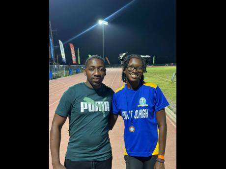 Credit: Contributed Coach Derol Gardener (left) of Penwood High with his athlete Shakeya Reid minutes after she won silver in the Class One 100 metres at the recent Corporate Area Championships.