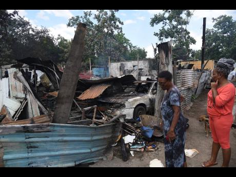 Passers-by look at what is left of the homes.