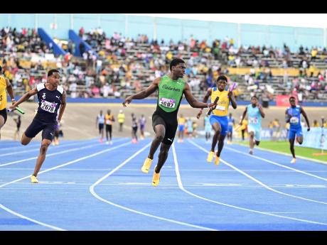 Khamani Gordon (second left) of Calabar High School looks to the clock as he crosses the finish line ahead of the field in the Class One boys’ 4x100m relay finals at Gibson McCook Relays 2025, at the National Stadium on Saturday, February 22, 2025. 
