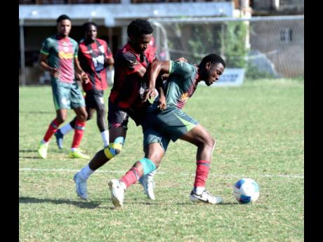 Arnett Gardens’ Rushike Kelson (second right) and Montego Bay United’s Okemo Jones battle for the ball during their Jamaica Premier League football game at Jarrett Park in Montego Bay on Sunday. The game ended 1-1.