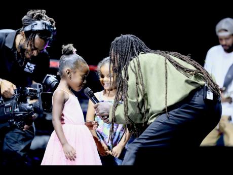 Credit: Nathaniel Stewart Photos Jesse Royal is joined on stage by daughter Korus (left) and her friend Nyah El during his performance on day two of Lost In Time Festival at Hope Gardens on Sunday.