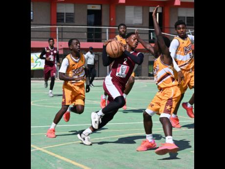 Herbert Morrison Technical High School’s Antonio Kerr (centre) tries to dribble by Manchester High’s Waine Green Jr (second right) and Elijah Henderson (left) during Game 1 in the best-of-three finals of the ISSA Under-16 basketball competition at Herbert Morrison on Monday.