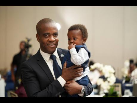 Commissioner of Police Dr Kevin Blake interacts with the son of a fallen cop.