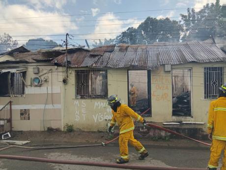 Credit: Rasbert Turner Firefighters drawing hose at a fire in SpanishTown .